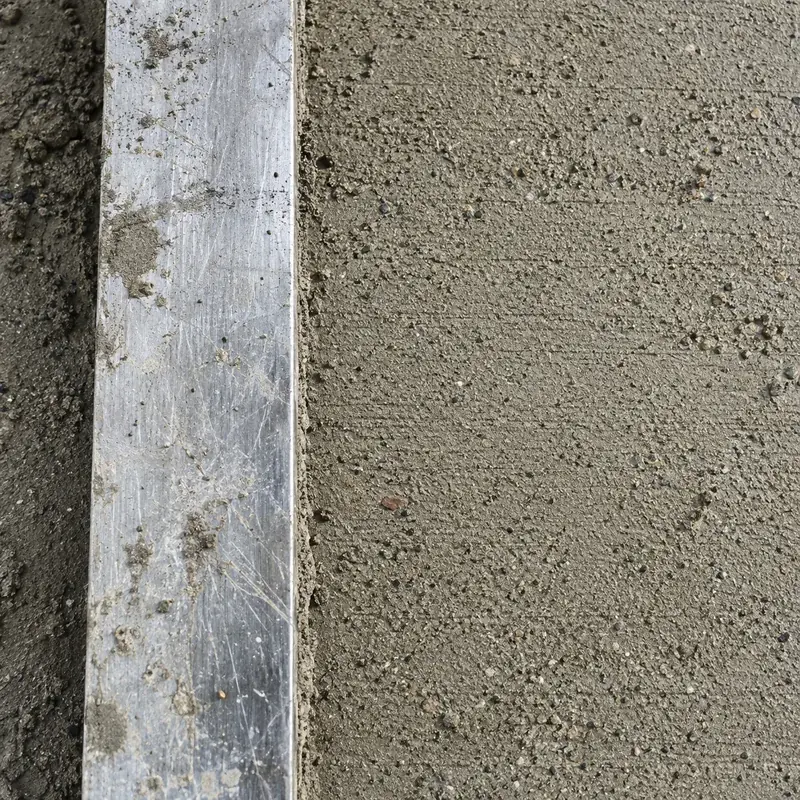 Top-down detail of a straightedge beside screed
