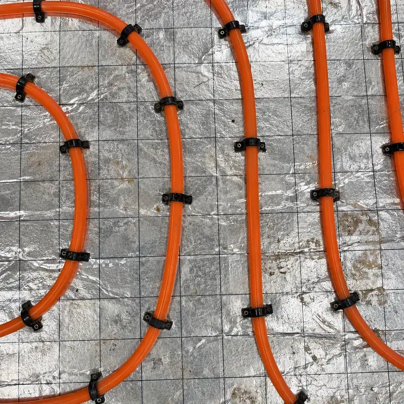 Top-down view of underfloor heating pipes over insulation
